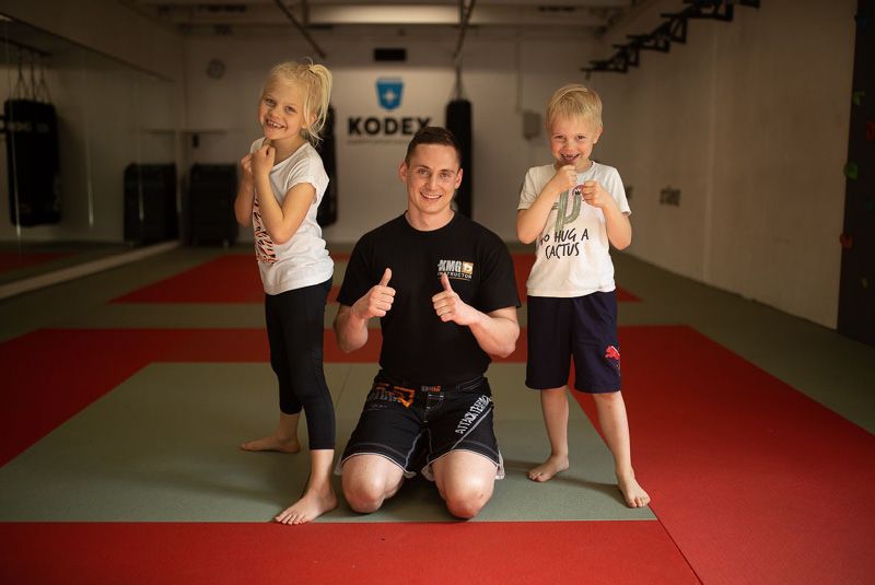 Victoria und Anton machen nach dem Selbstverteidigungskurs für Kinder ein Foto mit dem Krav Maga Global Trainer Kalle aus der Kodex Kampfsportakademie